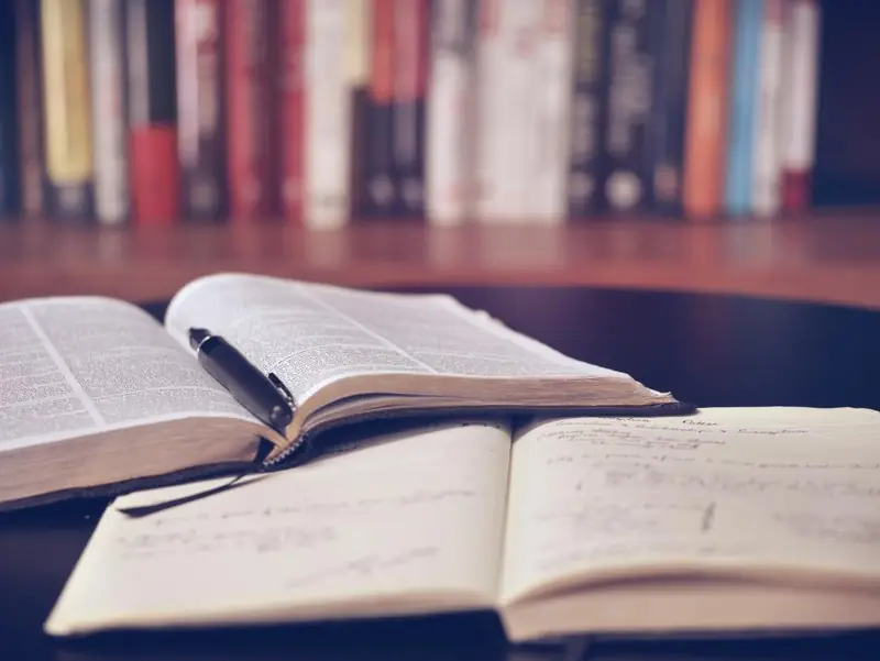 Livres ouverts et stylo sur une table de travail